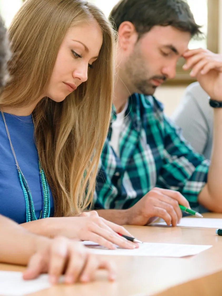 Two students working through a practice test together at a table