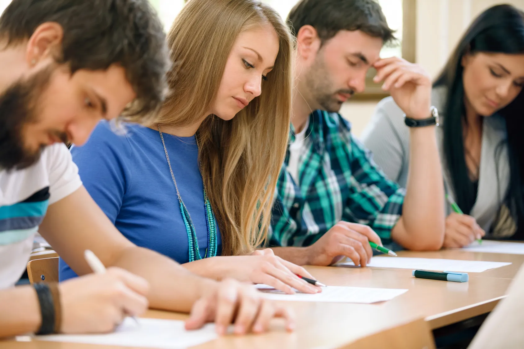 Students writing an exam at desks in a classroom