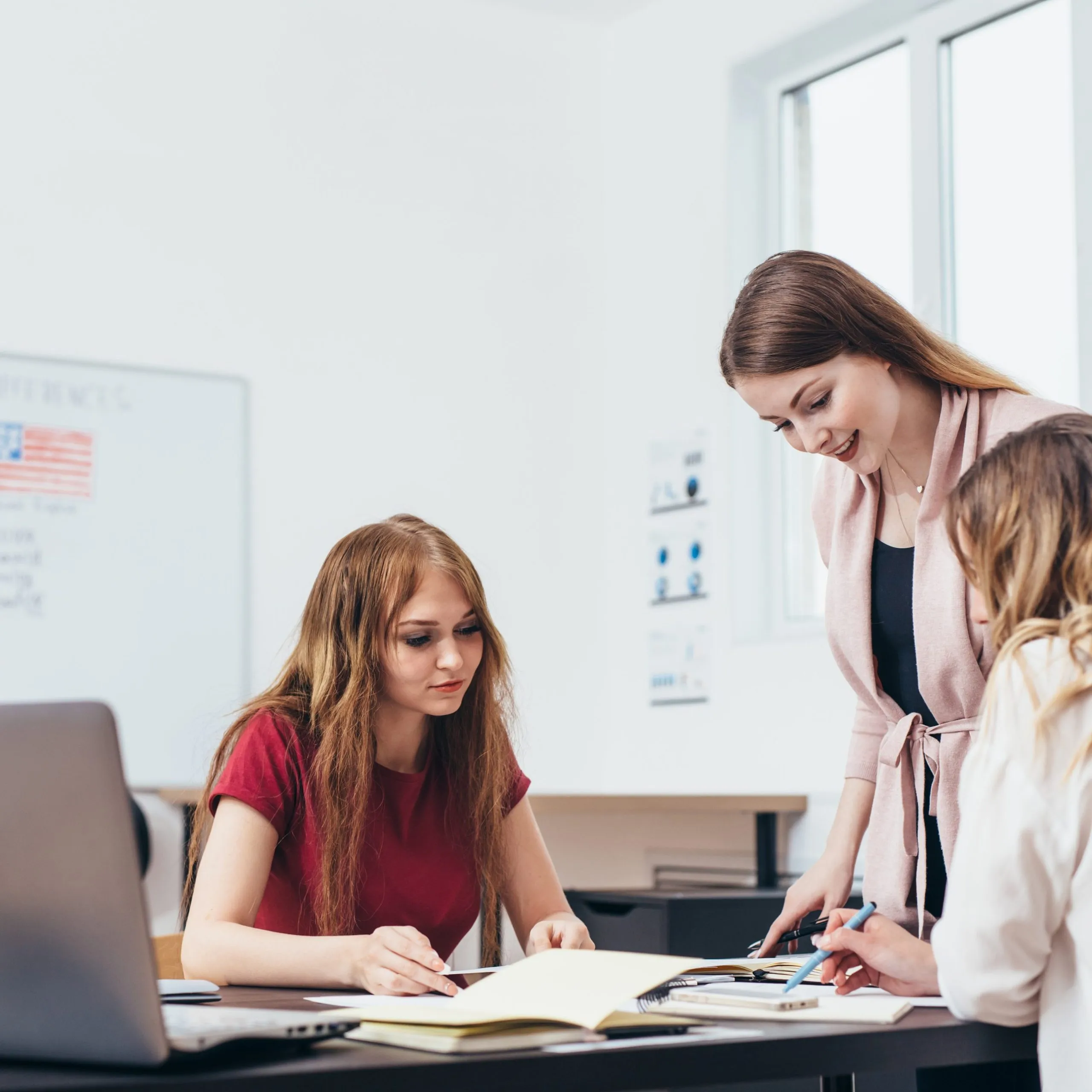 Women working together at a table with a laptop and notes