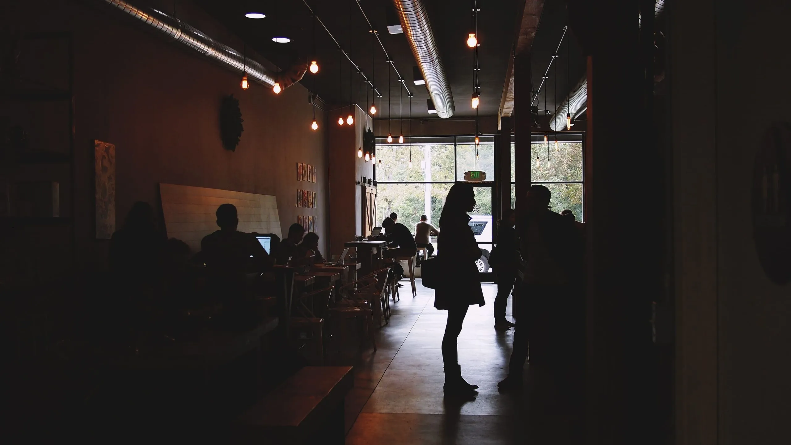 A dim, moody café interior with hanging lights